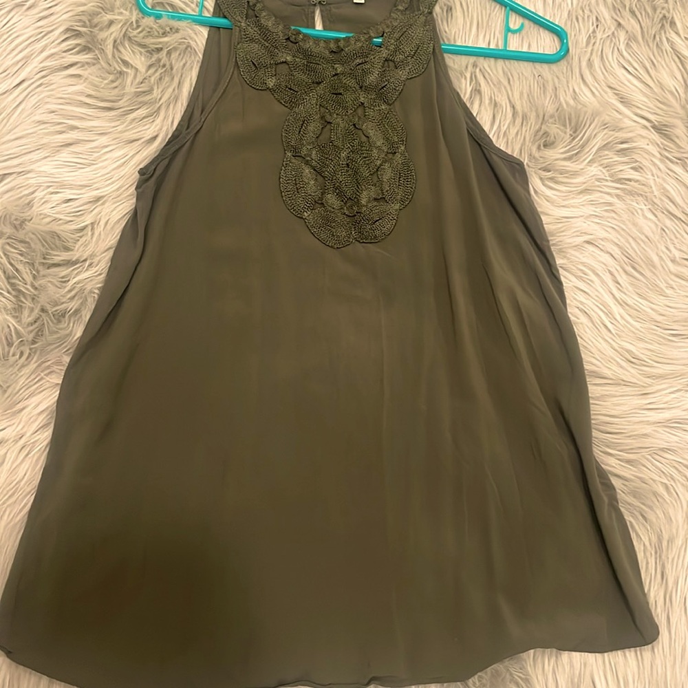 Green sleeveless top.